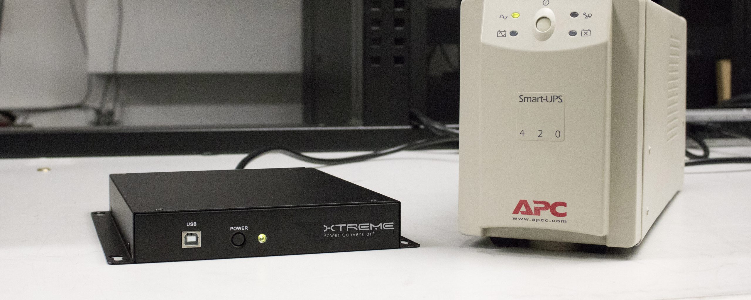 J60 lithium UPS next to an APC lead acid UPS at equivalent capacity — the J60 is 70% smaller
