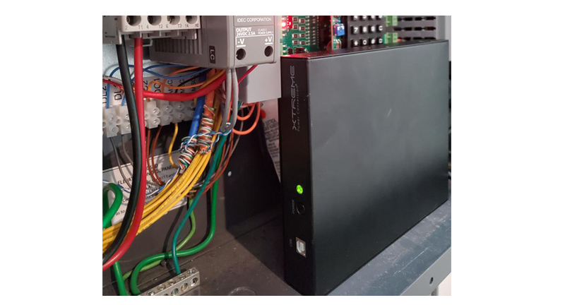 J60 lithium UPS installed inside an industrial control panel alongside PLC boards, terminal strips, and contactors