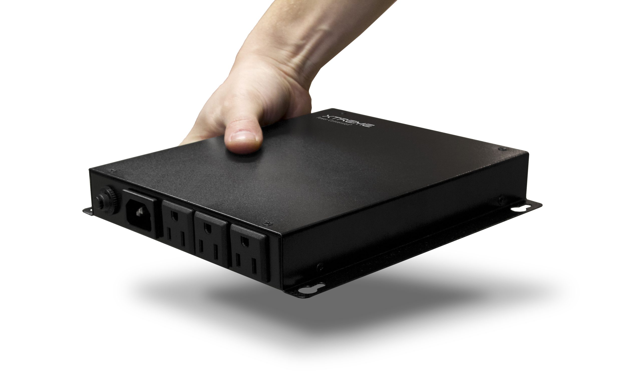 A hand holding the Xtreme Power J60 ultra-compact lithium UPS, showing its small, lightweight one-hand form factor with input inlet and three NEMA output receptacles