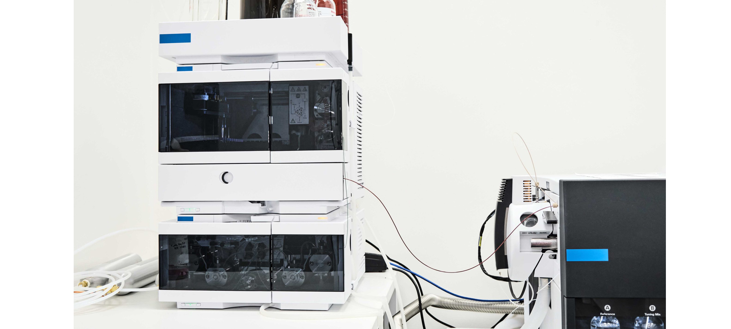 LC-MS liquid chromatography mass spectrometry system in a laboratory — solvent bottles on top, mass spec detector on right, analytical instrument requiring clean stable power