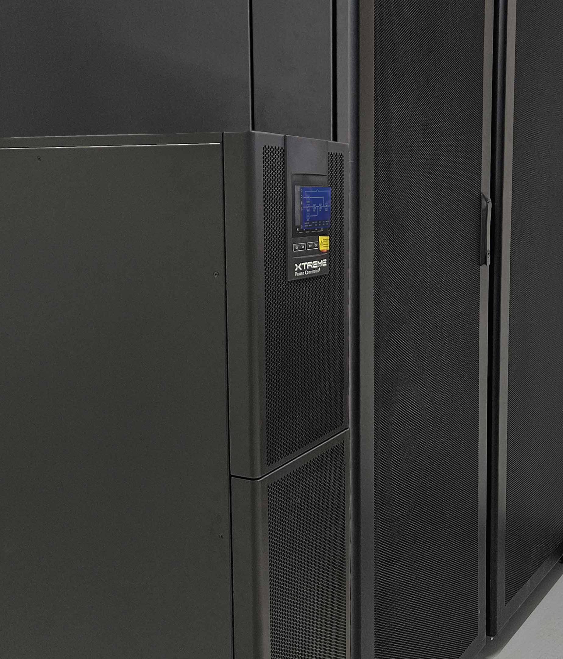 Xtreme Li90 integrated lithium UPS cabinet with front LCD standing beside a row of data center server racks
