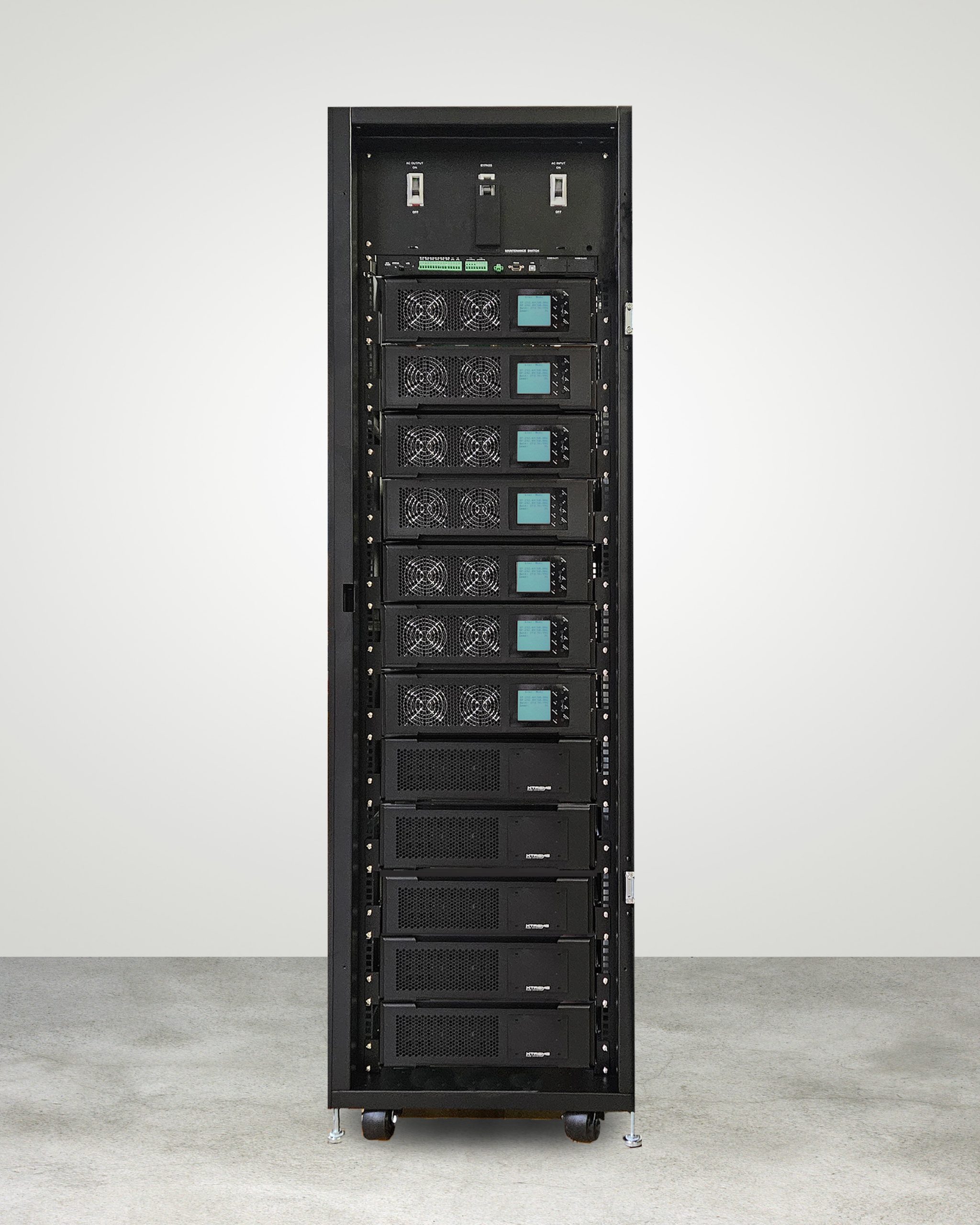 Xtreme Power M90S-12S modular single-phase UPS — full cabinet of stacked 6 kW power modules and battery modules above a maintenance-bypass switch