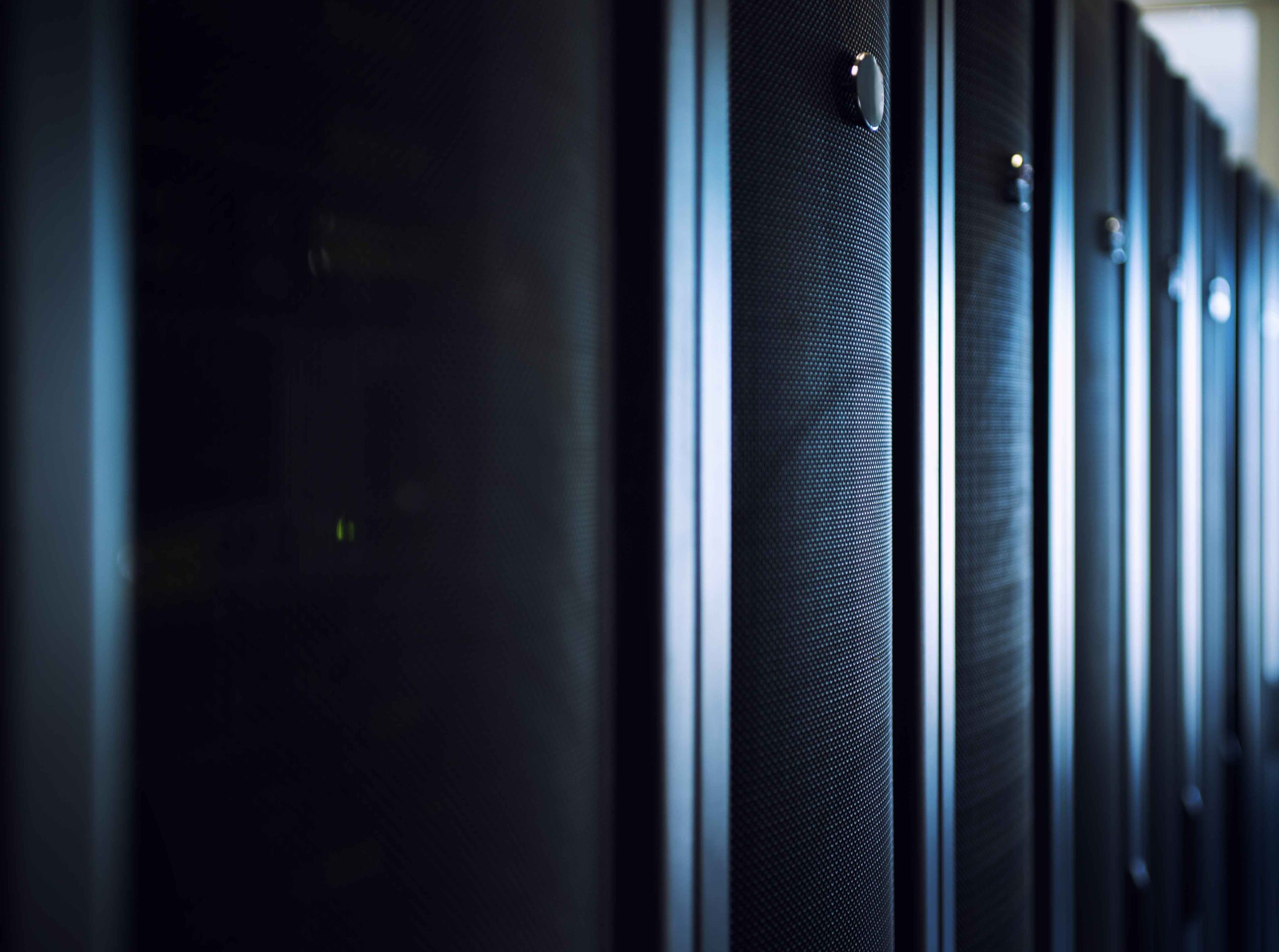 Row of illuminated data center server racks protected by scalable modular UPS systems