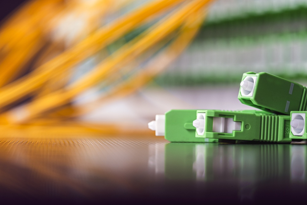 Green SC/APC single-mode fiber connectors and yellow patch cables in a passive optical LAN distribution frame