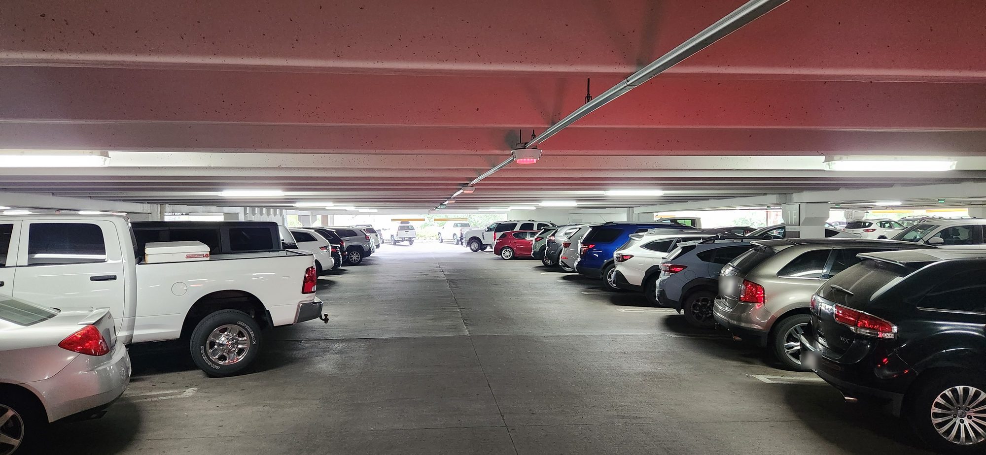 Overhead bay indicator and camera node of a parking guidance system on a garage deck, the equipment protected by a parking guidance system UPS